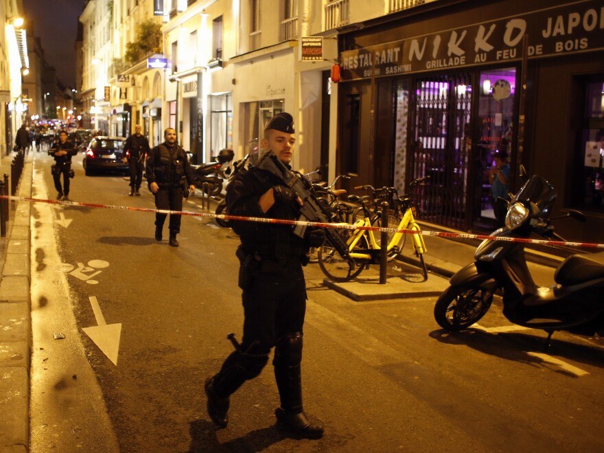 A police officer cordons off the area after a knife attack in central Paris on Saturday. The Paris police said the attacker was stopped by officers.