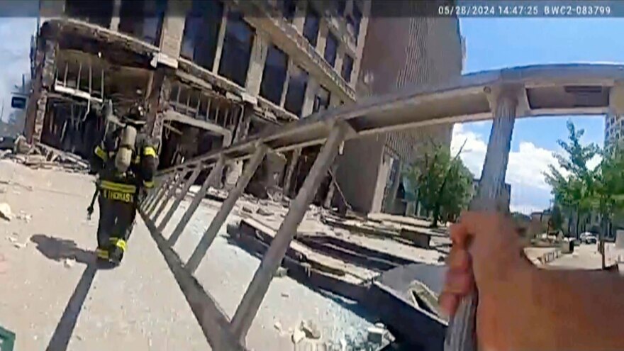 Police body camera video of mergency personnel approach a building following an explosion.