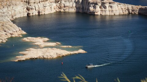 A boat passes rock formations in Lake Powell near the Utah-Arizona border, April 24, 2024. Forecasts now say the reservoir could reach new record lows by the end of 2026, heightening the stakes for states fighting over the Colorado River’s water.