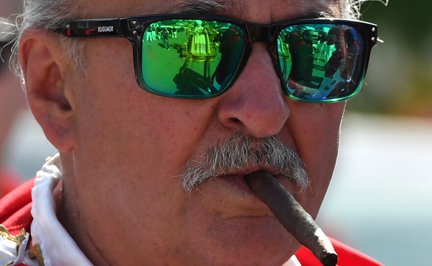 The statue of St. Ubaldo is reflected in a participant's glasses.