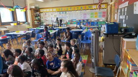 Students sit in front of an oscillating fan on the first day of school on Sept.