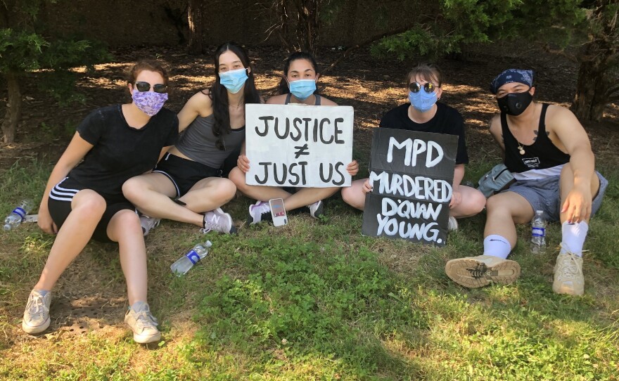 Natalie Spievack (third from left) and Raymond Sison (far right) take a break from protesting with friends at Malcolm X Park in Washington, D.C.