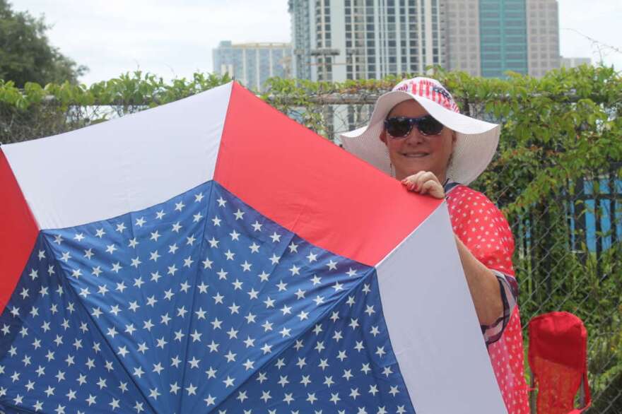 Laureen Vartanian sports a patriotic umbrella to match her equally patriotic outfit, as she waits in line for Trump's re-election rally. Photo by Paola Chinchilla.