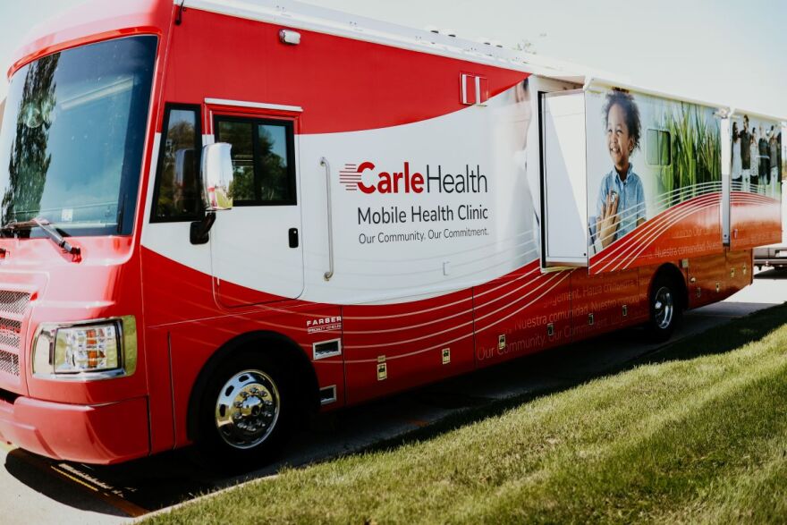A red mobile clinic bus from Carle Health.