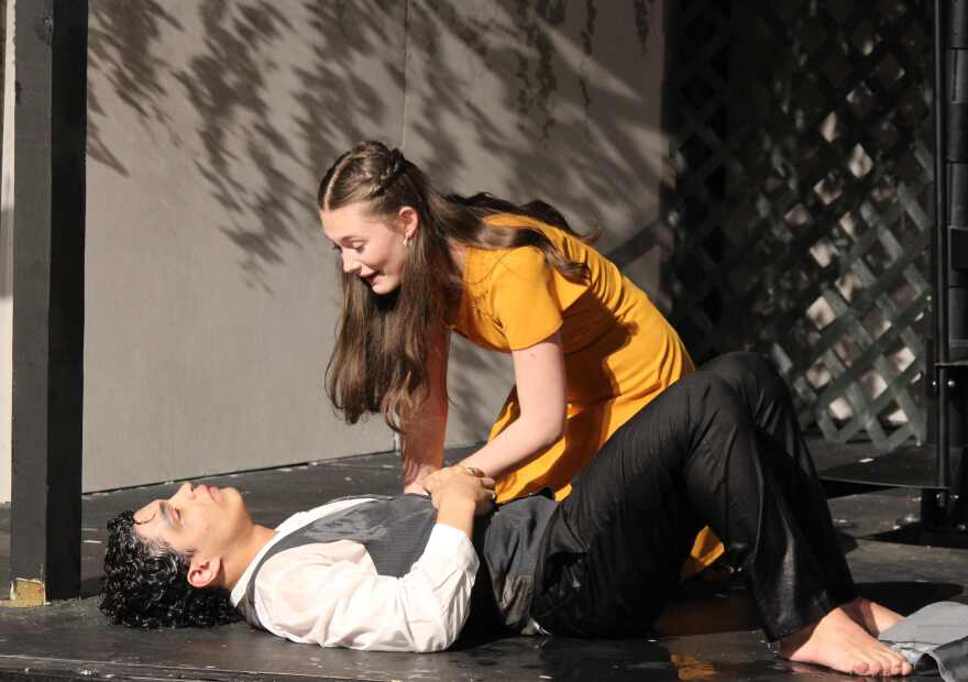 Eurydice (Ella Maas) discovers that her father, believing his daughter has left the Underworld with Orpheus, has tragically submerged himself in the River of Woe. 