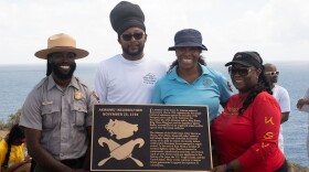 Ahmad Toure, Visitor Service Program Manager, VI National Park Service, Angel Bolques, Senator-at-Large, Stacey Plaskett, Delegate to Congress, and Shikima Jones, St. John Administrator, are photographed with the newly unveiled plaque at St. John's Ram Head.