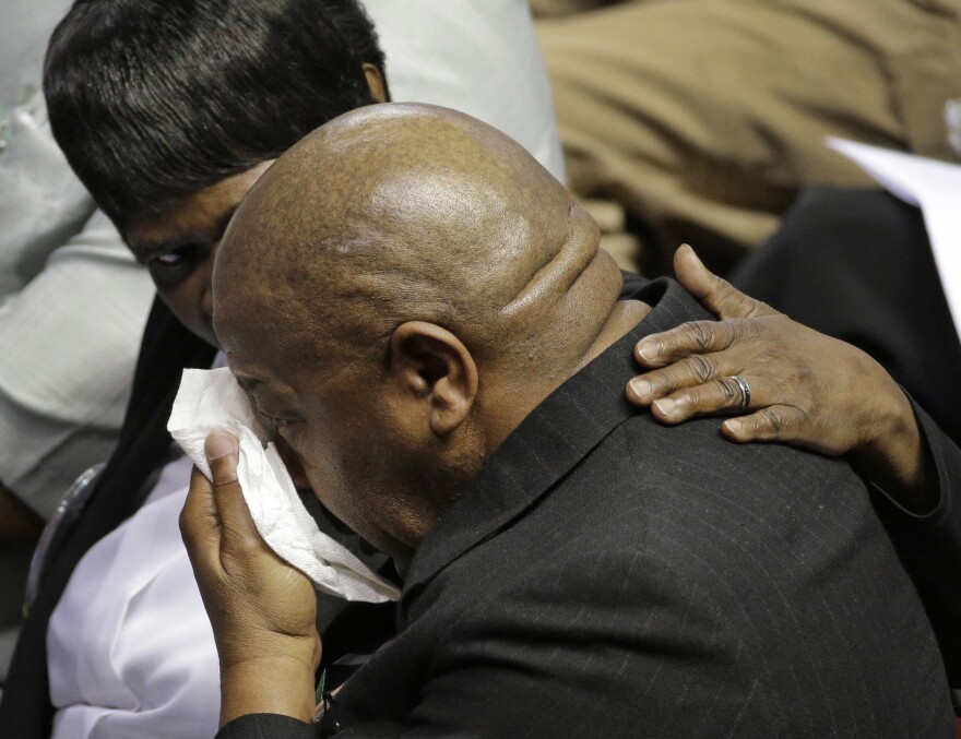 A mourner is comforted during a memorial in Charleston, S.C., Friday, June 17, 2016 on the anniversary of the killing of nine black parishioners during bible study at Mother Emanuel AME Church.