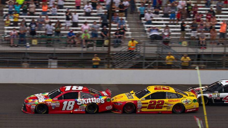 Kyle Busch (18) used a push from Joey Lagano (29) to take the lead on a restart in the closing laps of the Brickyard 400.