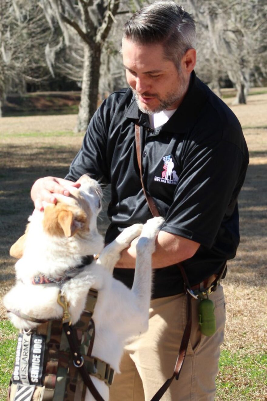 Randy Dexter pets his service dog Captain on Wednesday while attending the ribbon-cutting ceremony. (Tangela Morris/WUFT News)