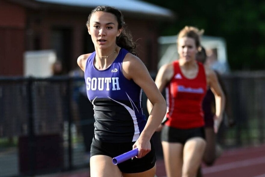 Violet Hall competes in a relay at a high school track meet.