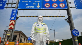 A transit officer, wearing a protective gear, controls access to a tunnel in the direction of Pudong district in lockdown as a measure against the Covid-19 coronavirus, in Shanghai on March 28, 2022. (HECTOR RETAMAL/AFP via Getty Images)