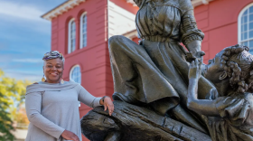 Adrian Holmes poses with the "A Beacon of Hope" Harriet Tubman statue in front of the Dorchester County Courthouse in Cambridge.