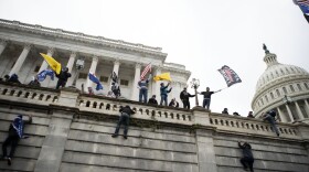 Supporters of President Donald Trump climb the west wall of the Capitol in Washington on Jan. 6, 2021.