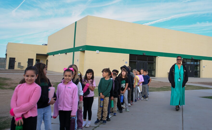 A class walking outside wished Superintendent Horne "Buenos Dias!"