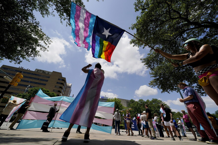 FILE - Demonstrators gather on the steps to the State Capitol to speak against transgender-related legislation bills being considered in the Texas Senate and Texas House, May 20, 2021, in Austin, Texas. A Texas judge on Friday, June 10, 2022, temporarily blocked the state from investigating families of transgender children who have received gender-confirming medical care, a new obstacle to the state labeling such treatments as child abuse. (AP Photo/Eric Gay, File)