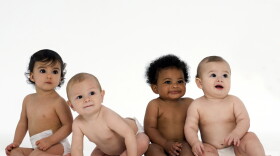 Four multi-ethnic babies posing.