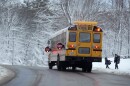 Children are picked up by their school bus following a day off due to a winter storm, Wednesday, March 15, 2023, in Poland, Maine. The storm dumped heavy, wet snow on parts of the Northeast, causing tens of thousands of power outages.