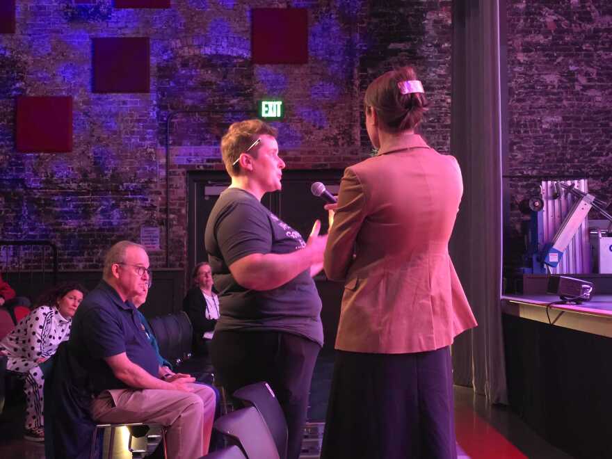 Members of the audience line up to ask questions from the panelists.