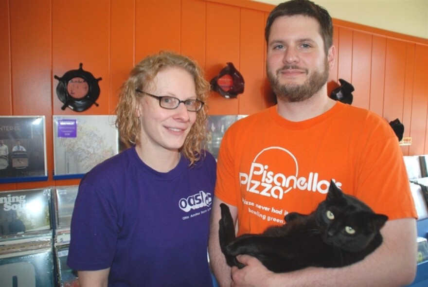 Melanie Hershberger and Kevin Neudecker of <em>Music Saves Record Shop</em> pose with Vinyl the cat.