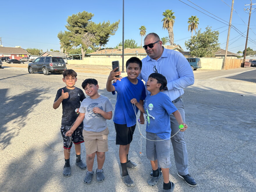 Mendota Mayor Victor Martinez poses for a selfie with a group of neighborhood boys on Sixth Street on Aug. 26, 2026.
