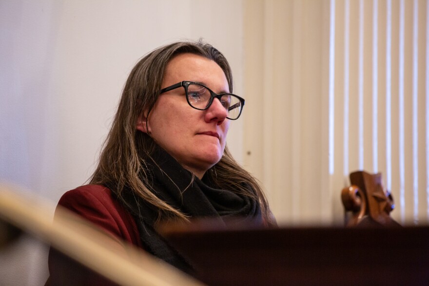 A woman with long hair and glasses