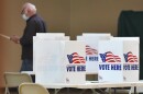 A voter carries his ballot to be counted Tuesday morning at Southeast Community Center where a slow, but steady trickle of voters moved through the polling location.