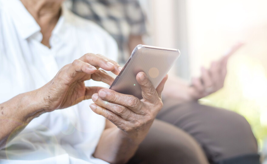 This stock photo shows a senior citizen using a smartphone.