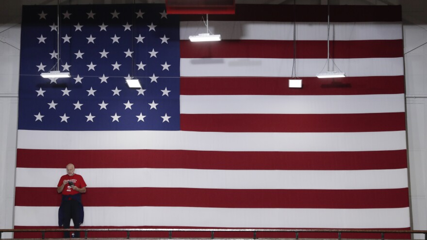 A volunteer stands in front of an American flag before President Trump speaks at a rally last week in Indianapolis. Indiana is a key Senate battleground state for the GOP.