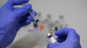 In this March 2, 2021, file photo, a pharmacy technician loads a syringe with Pfizer's COVID-19 vaccine.
