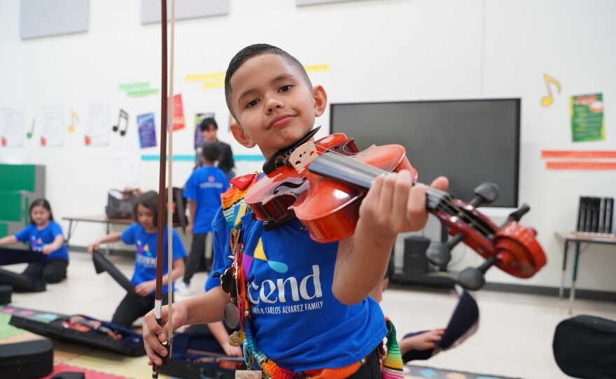 Child with a violin in one of TOSA's youth programs