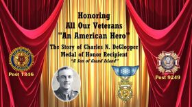 Background: red and gold theater curtains. In black text, centered: HONORING ALL OUR VETERANS "AN AMERICAN HERO" THE STORY OF CHARLES N. DEGLOPPER MEDAL OF HONOR RECIPIENT "A SON OF GRAND ISLAND"