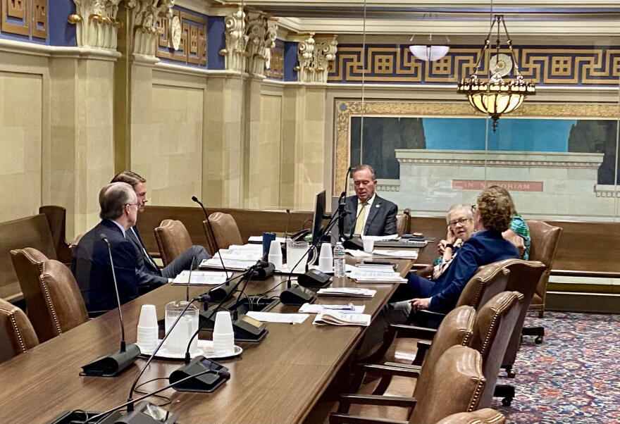 Oklahoma Treasurer Todd Russ, seen through a glass window, discusses options with attorneys during an executive session of the Tobacco Settlement Endowment Trust Board of Investors at the Capitol in Oklahoma City on Wednesday, July 1, 2026.