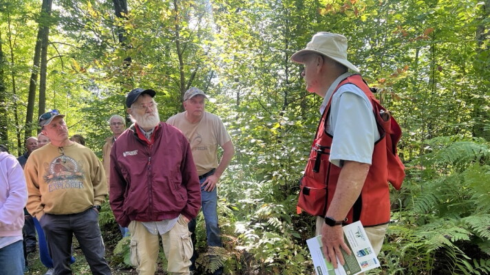 Gary Anderson speaks to a crowd touring his property Sept. 12 near Outing. 