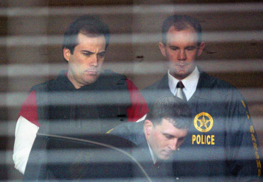 FILE - In this April 13, 2005, file photo, convicted bomber Eric Rudolph, left, is led to a waiting police car by U.S. Marshals as he leaves the Jefferson County Jail for a hearing in Birmingham, Ala. Rudolph, who was sentenced to life imprisonment after pleading guilty in the fatal bombing of an Alabama abortion clinic and the 1996 Atlanta Olympics, is arguing he deserves a new sentencing hearing or a chance to withdraw his plea. Rudolph filed a handwritten challenge in June 2020, and a public defender submitted further arguments in the case this week, WBMA-TV reported. (AP Photo/John Bazemore, File)