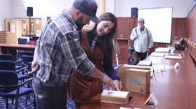 State Archivist Ashley Miller, back, shows off a 1911 record of the first election where a woman ran for governor as part of a showcase for American Archives month at the State Archives in Concord on Oct. 17, 2024.
