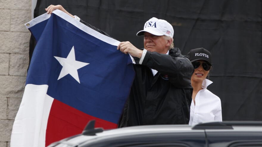 Trump holds up a Texas flag after speaking with supporters outside Firehouse 5 in Corpus Christi, Texas, where he also received a briefing from state and local officials.