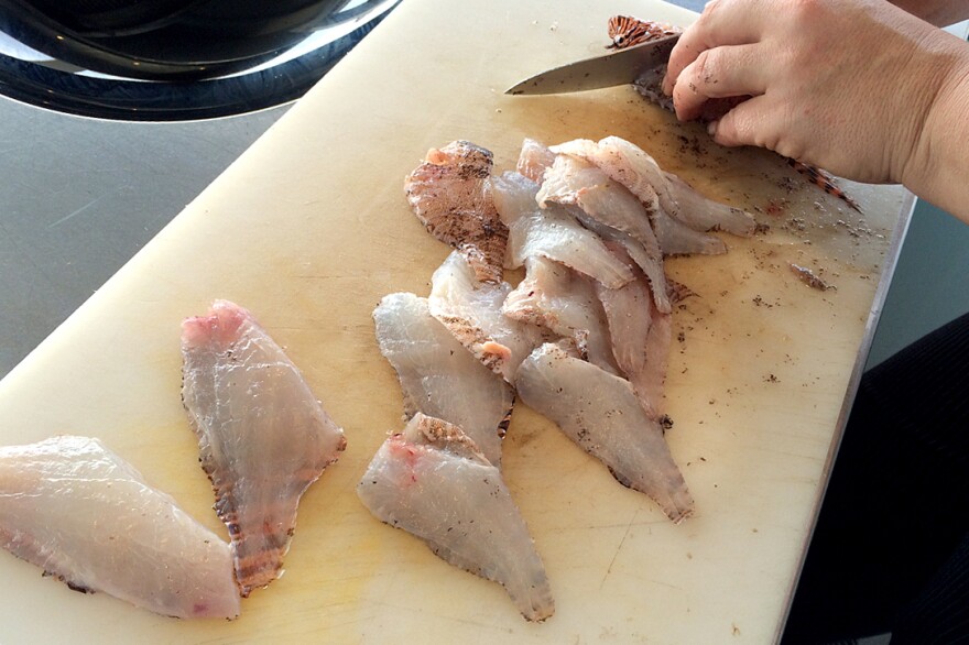 Chef Ellen Bross fillets lionfish caught by Sean Carberry.