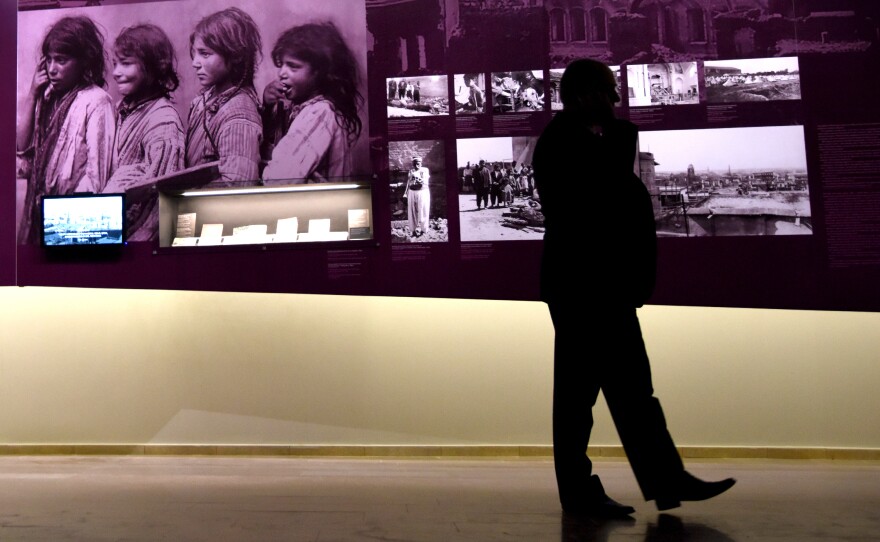 A man walks by photographs at the Armenian Genocide Museum in Yerevan, Armenia, on Tuesday. Armenians will mark the 100th anniversary of the killings on Friday.