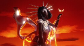 Cover art from a music album shows an immense statue of a kneeling woman with a large butterfly about to land on its outstretched hand.