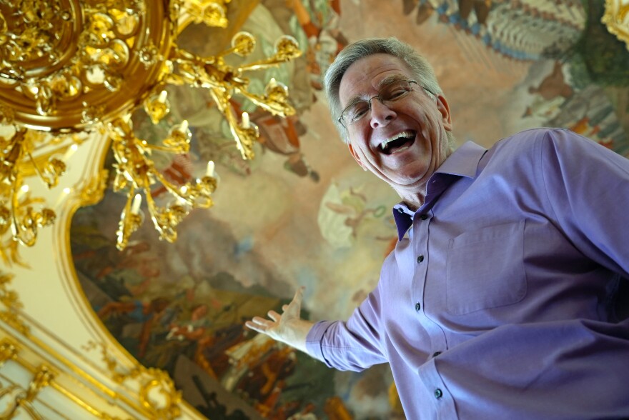 Rick Steves points up at a painted ceiling