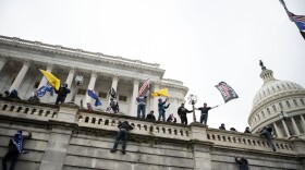 Supporters of President Donald Trump climb the west wall of the Capitol in Washington on Jan. 6, 2021.