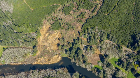 An aerial photo from May shows the massive December landslide that swept down off Weyerhaeuser property, across Oregon Highway 229 and destroyed or damaged houses along the Siletz River.