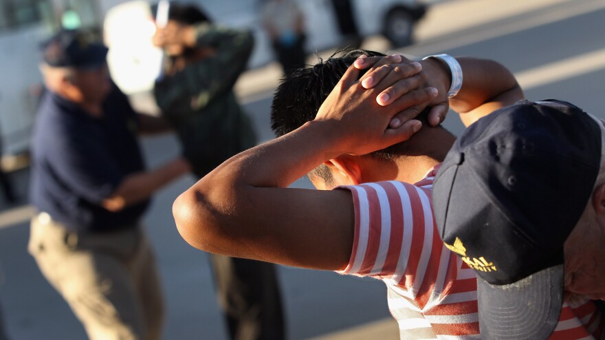 Employees with the U.S. Immigration and Customs Enforcement agency search Guatemalan immigrants before they are put aboard a deportation flight to Guatemala City on June 24, 2011, in Mesa, Ariz.