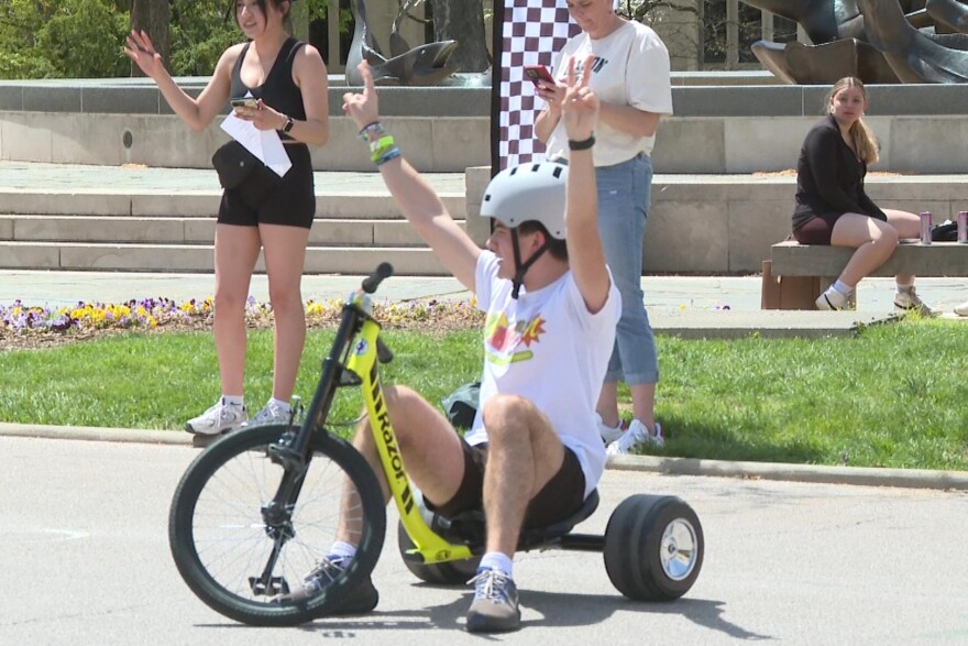 A racer in the Little Little 499 celebrates after crossing the chalk-marked finish line at Showalter Fountain April 23.