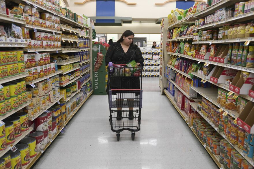 Jaqueline Benitez pushes her cart down an aisle as she shops for groceries at a supermarket in Bellflower, Calif., on Monday, Feb. 13, 2023. Benitez, 21, who works as a preschool teacher, depends on California's SNAP benefits to help pay for food.