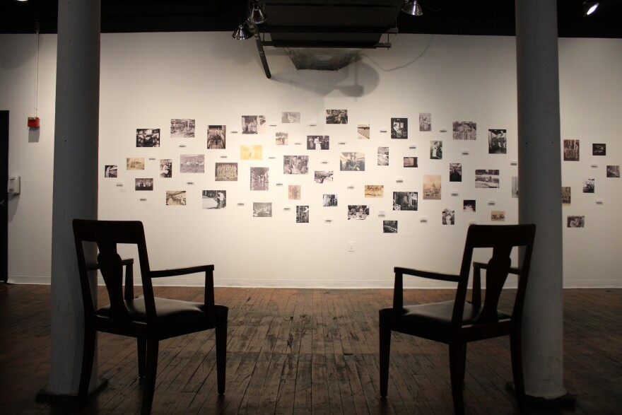 The exhibit also features a wall covered with historical photographs from the museum's collection.