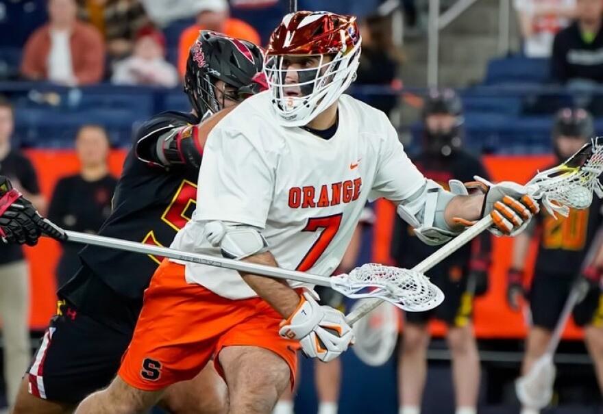 Syracuse midfielder Michael Leo (7, White) dodges a defender in No. 2 SU’s 11-9 win over No. 1 Maryland on Friday, February 13.