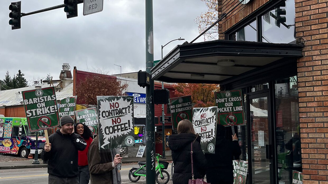 Outside a Seattle Starbucks, baristas are picketing with signs that read, "No Contract? No Coffee!" and "Baristas on Strike." The baristas, who are represented by Starbucks Workers United, are asking people to boycott the coffee company while they withhold their labor.