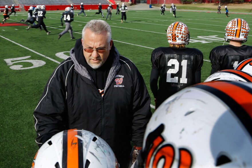 Washington Community High School coach Darrell Crouch talks with his team during football practice at Illinois State University's Hancock Stadium Wednesday, Nov. 20, 2013, in Normal, Ill. The team has a state semifinal playoff game Saturday, but their hometown is just digging out from a powerful tornado that destroyed a number of players' homes. Practice had to be moved, in part, because the high school has no drinkable water service. (AP Photo/Seth Perlman)