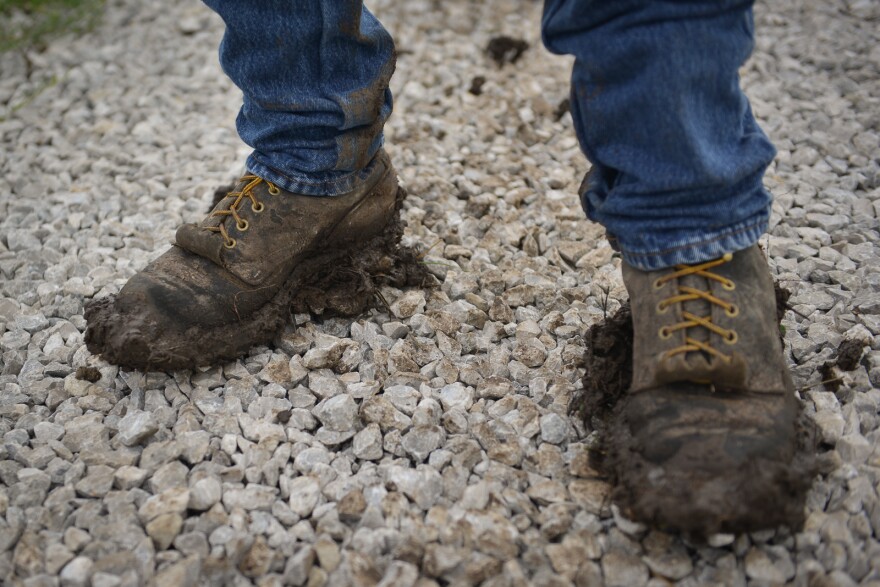 Mark Tubby's shoes are caked with mud while working on his 20 acre farm in Cleveland recently.